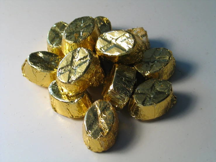 a pile of chocolate pieces that are gold