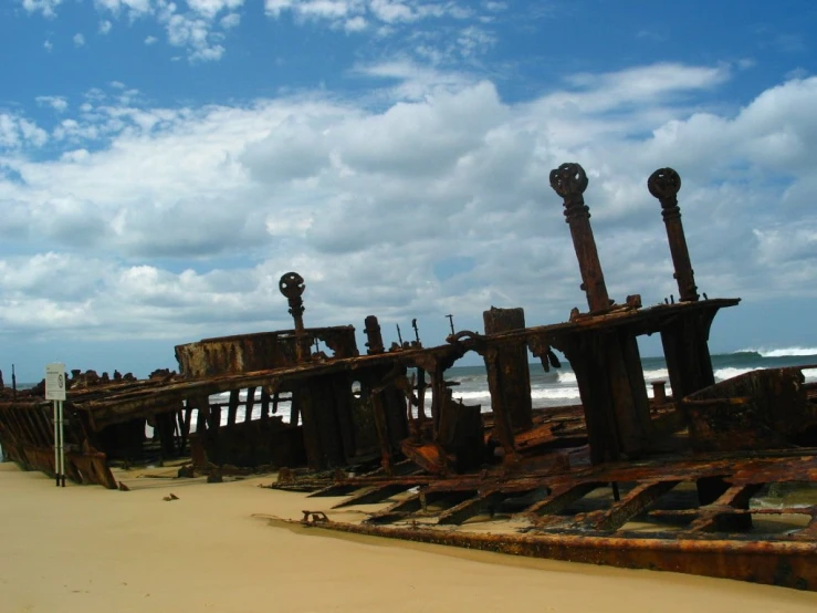an old wooden boat dock sitting on a beach