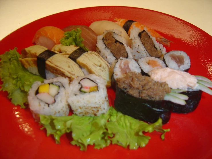 many sushi are laying out on a red plate