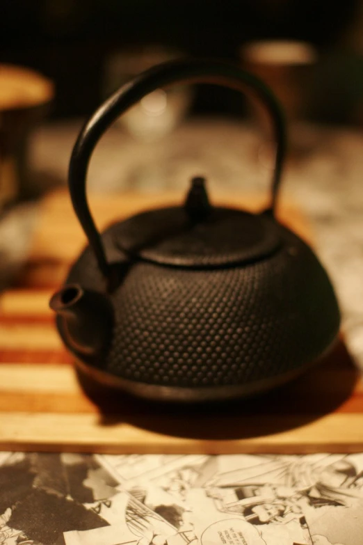 a kettle sits on top of a wooden  board