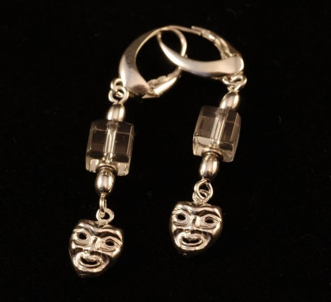 the pair of earrings is hanging on a black background
