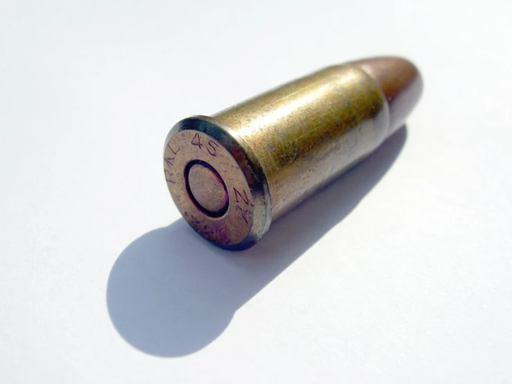 a close up of a golden bullet on a white background