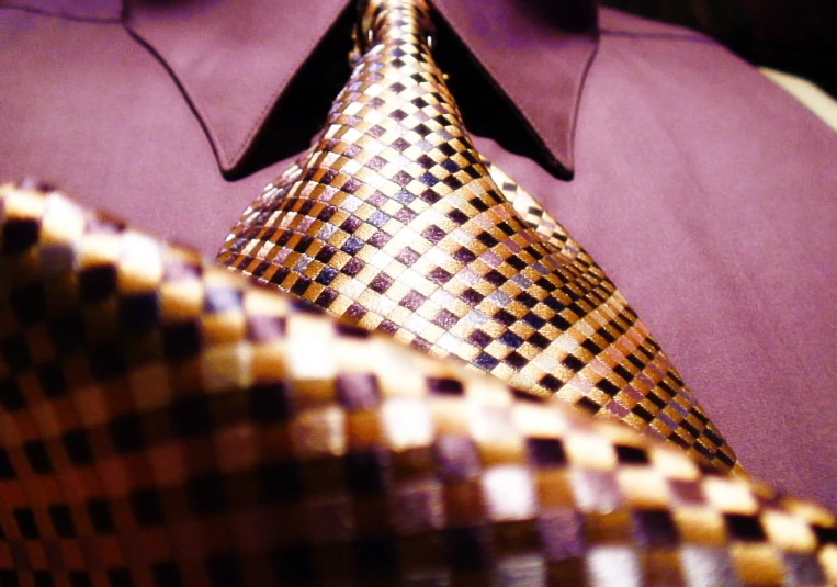 a close up of a person wearing a checkered tie
