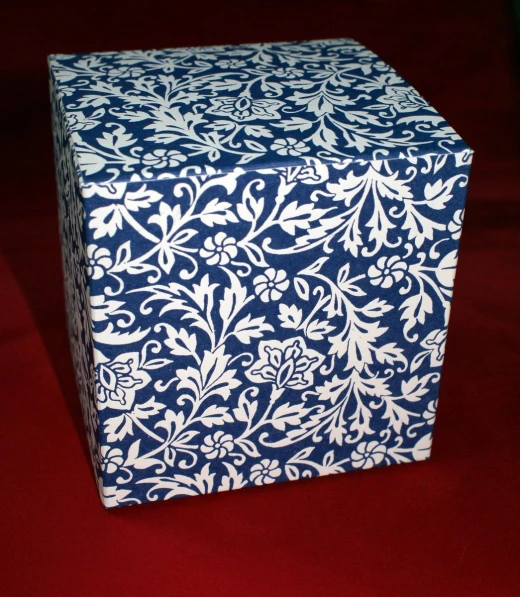 a blue and white patterned box sitting on top of red carpet