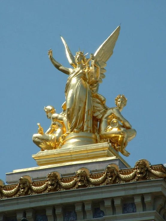 golden angel on top of the tower with statues