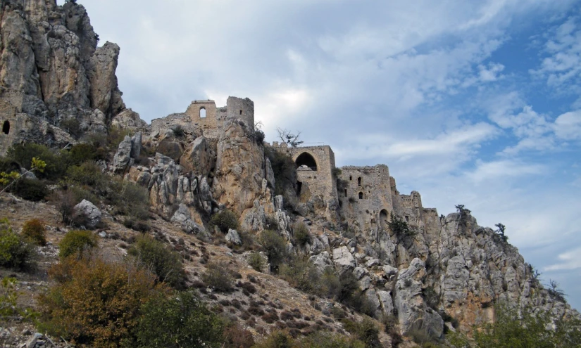 a castle with holes on it on top of a mountain