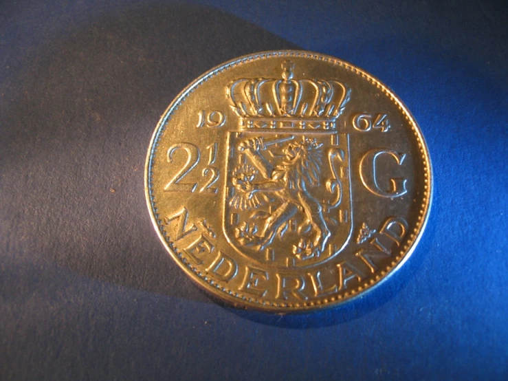 an antique style coin sits on a blue surface