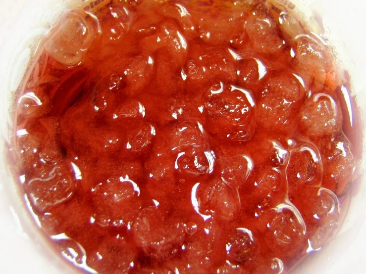 red jelly is being sold in a plastic container