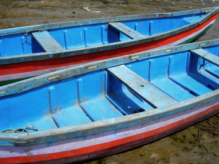 two boats are lined up on the shore