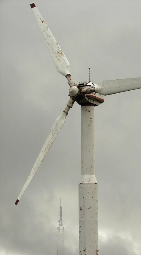 a wind turbine is shown in the foreground against a cloudy sky