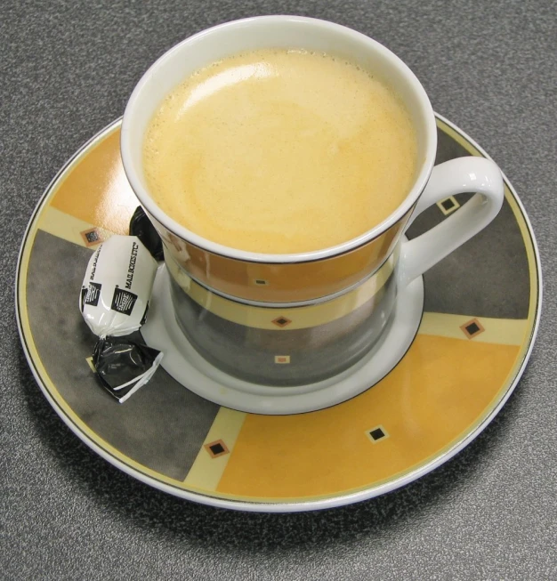 cup on saucer filled with liquid sitting atop plate