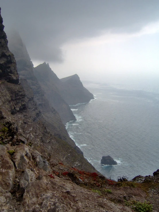 a view from a rocky cliff overlooking the ocean