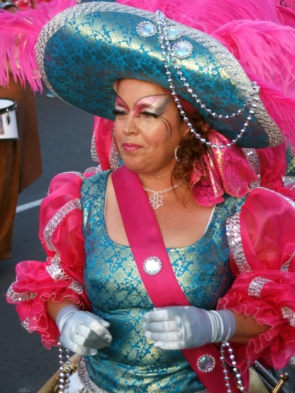 a woman is walking in pink and blue with feathers on her head