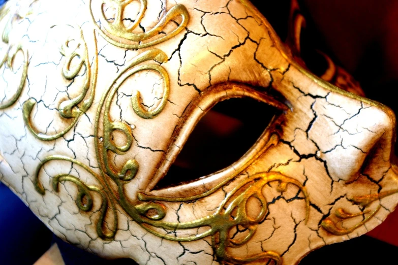 a gold and black mask sitting on top of a table