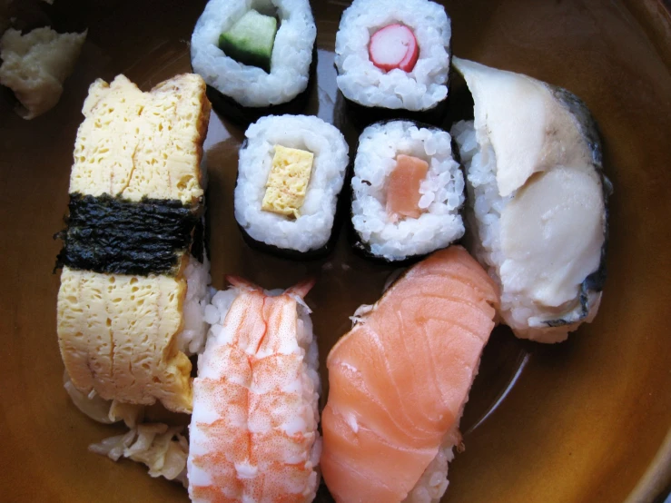 a small bowl holds an assortment of sushi