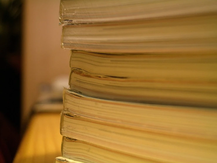 stack of yellow books on desk with blurred backgroun
