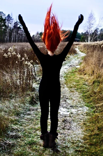 a woman standing in a field with her arms up
