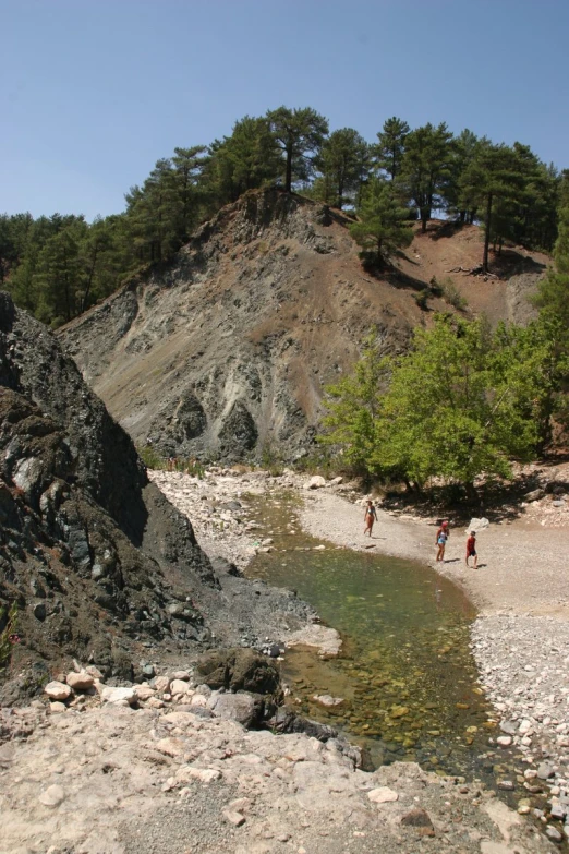 a group of people standing on top of a large cliff