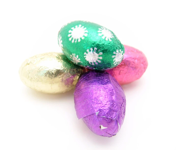 four wrapped chocolate eggs in pastel shades