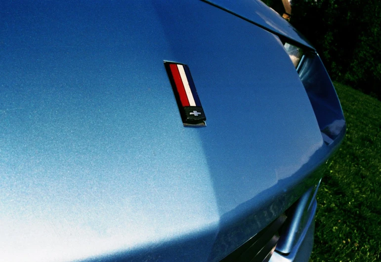 the side of a blue car has a thin red stripe