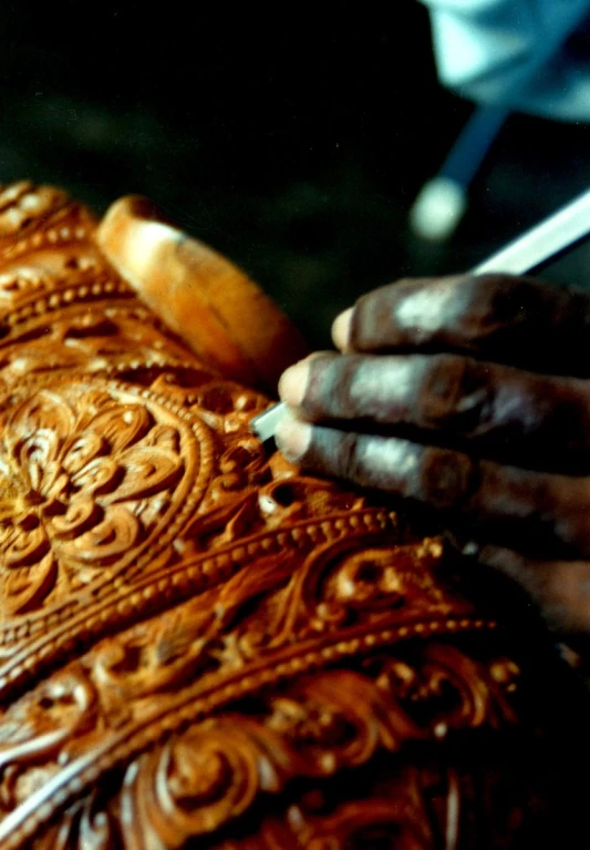 a person using a sewing machine to stitch a wooden piece