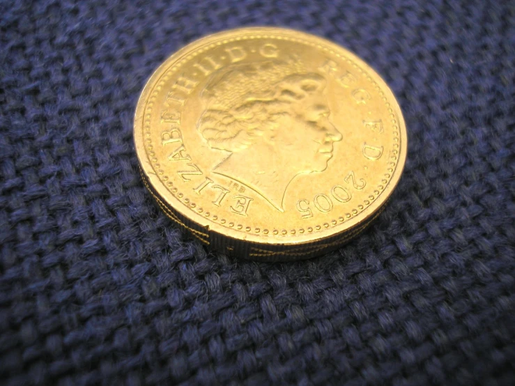 a closeup po of a gold coin with writing on it