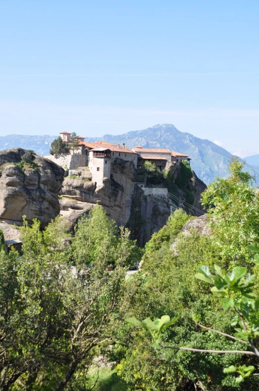 a small stone building on a steep mountain