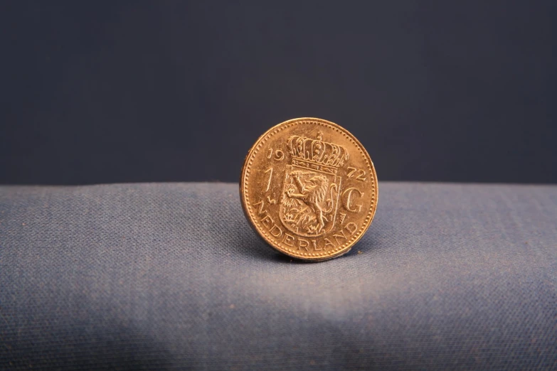 a coin lying on the blue cloth that appears to be on top of a blanket