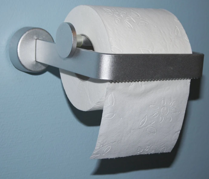 a close - up of a toilet roll that is open with a strip of metal