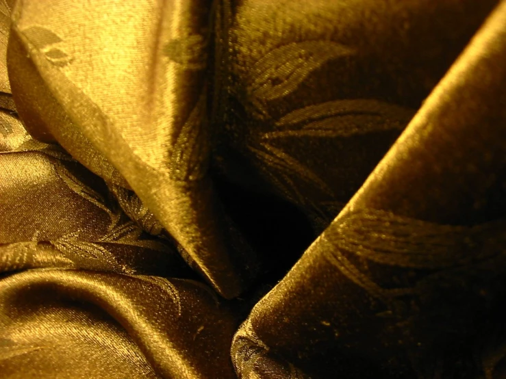 a gold cloth with many folds and a piece of fabric on it