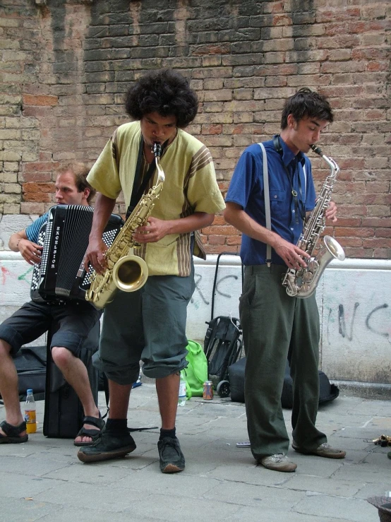 two men playing instruments on the side of a building