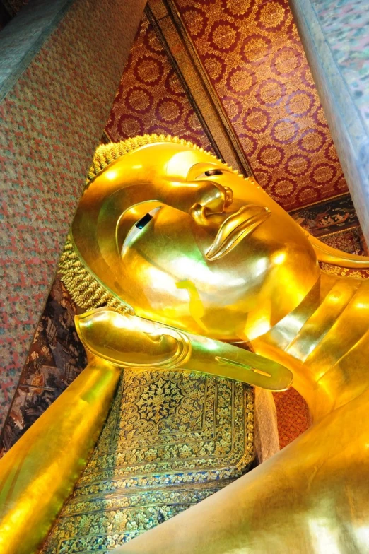a golden buddha statue sitting on top of a floor