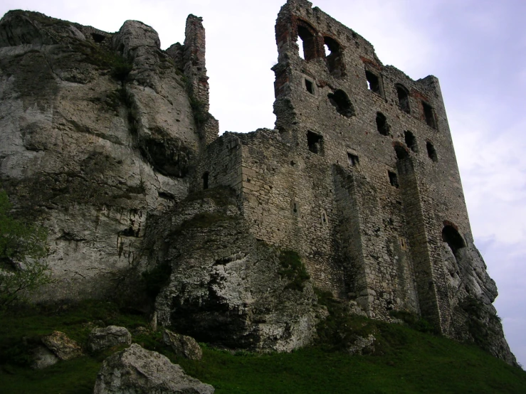 the ruins of a castle that is being held back by massive rocks