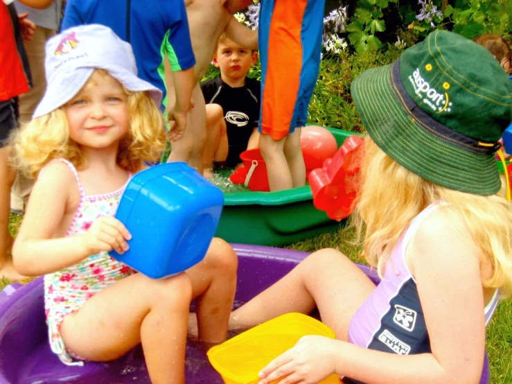 two girls and boy playing with toys in a pool