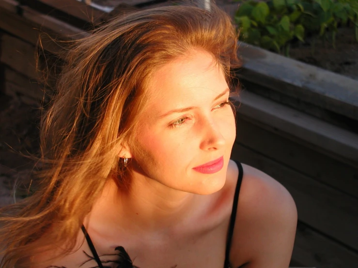 a woman with long red hair sitting on a bench