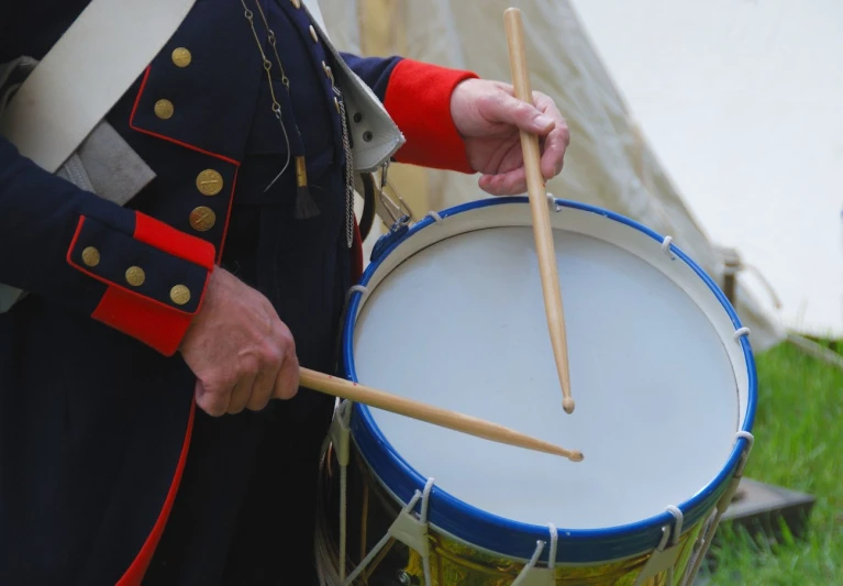 a person in blue military uniform holding a drumset