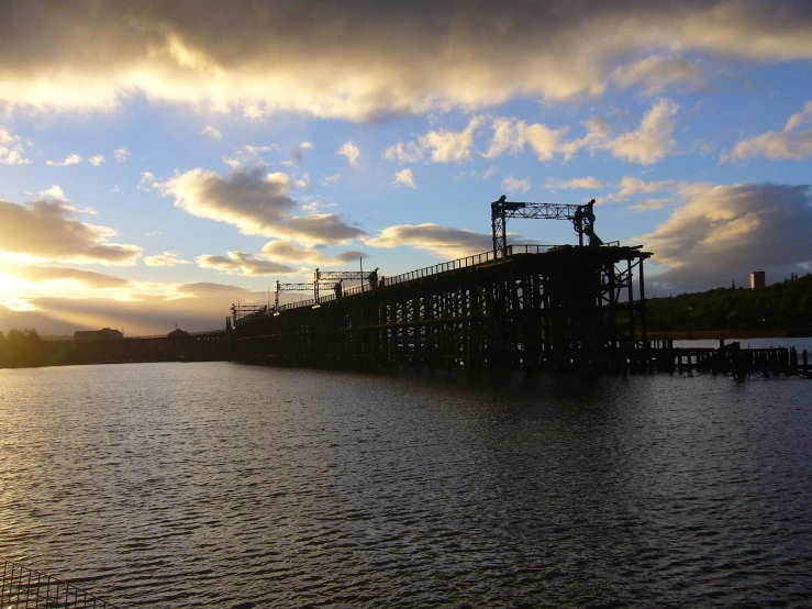 a barge sits at the end of a long pier on a lake