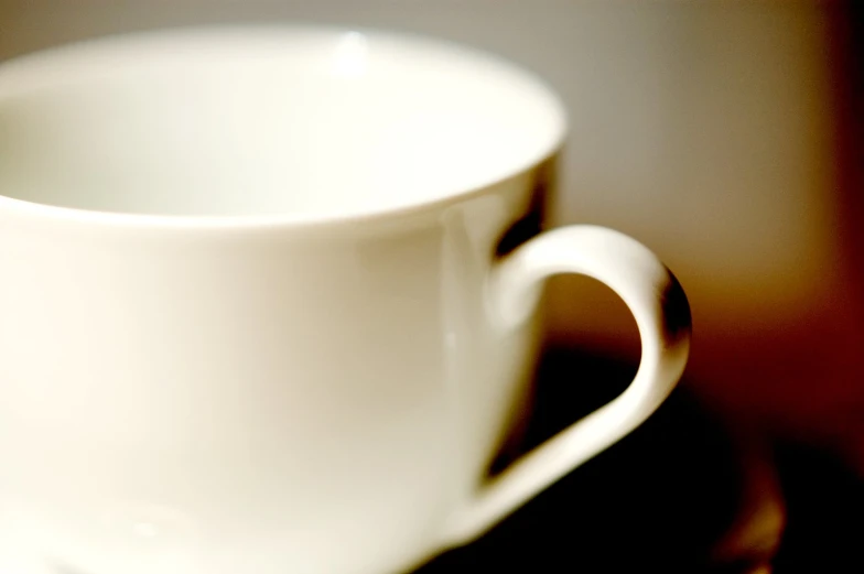 an empty white coffee cup sitting on top of a table