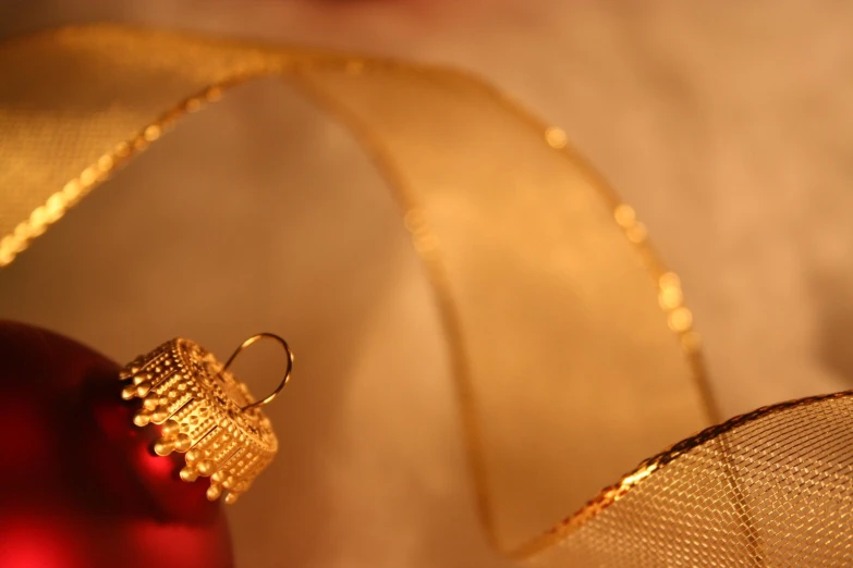 a gold wire ornament on a shiny red ornament