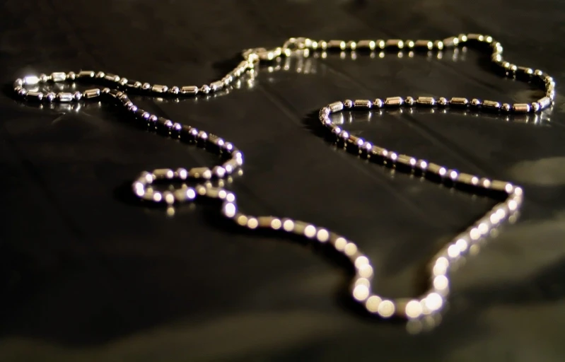 a long purple necklace with a small beaded necklace hanging off it's side