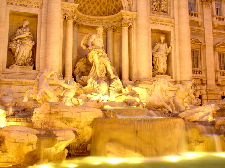 the statues on the building are illuminated by lighting