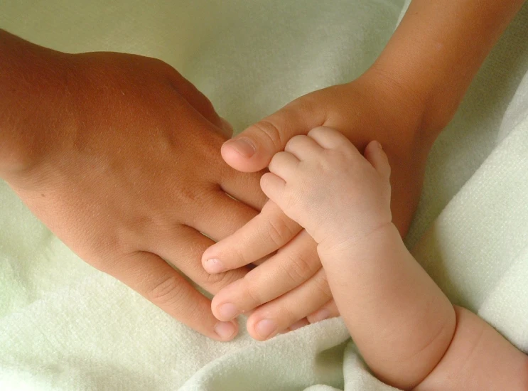 a person's hands holding a baby's leg