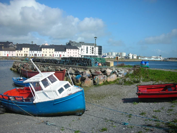 boats in the water next to the shore of a marina