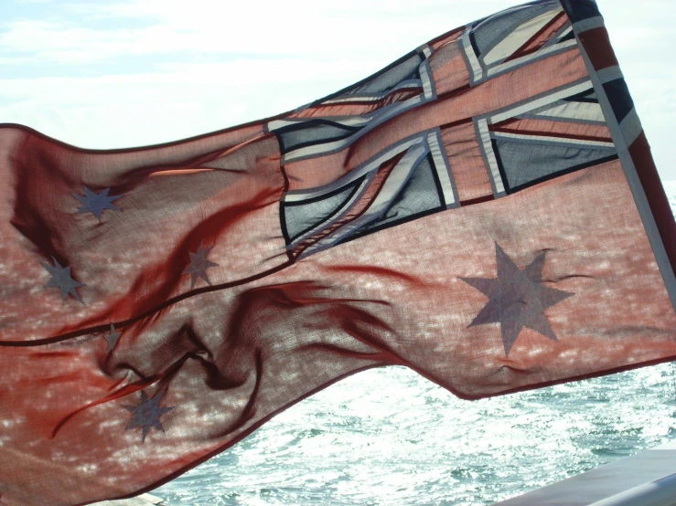 a very large flag flying in the wind on a boat