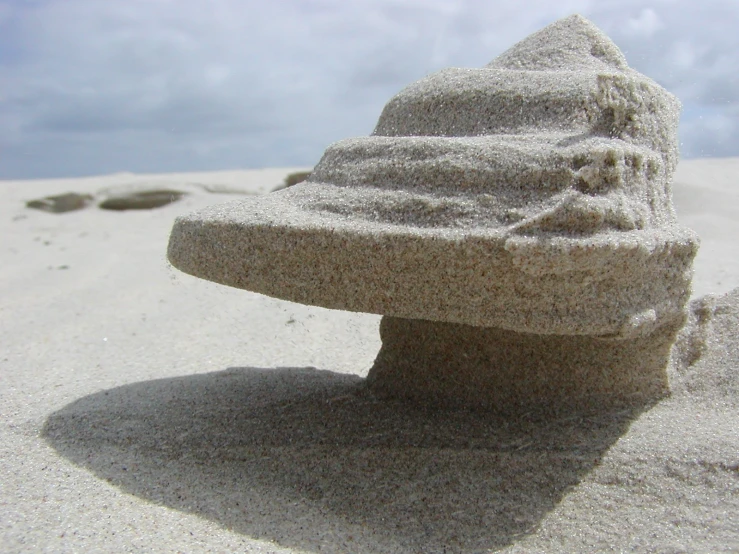 a stone monument is sitting on the beach