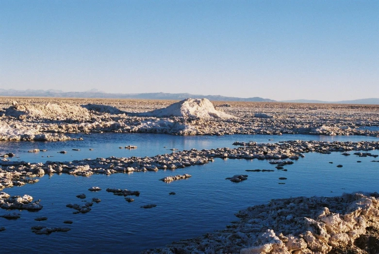 a lake surrounded by barren mountains and other large rocks