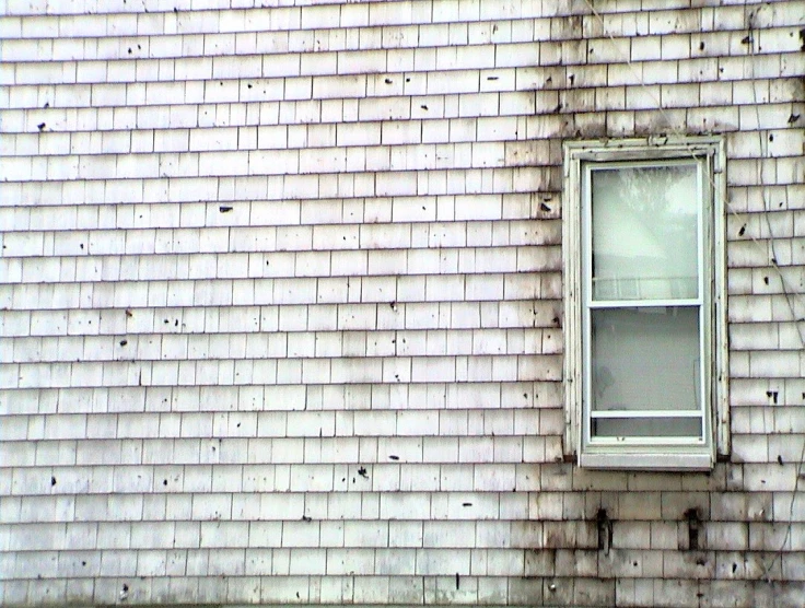 a white window on a brick wall by an old building