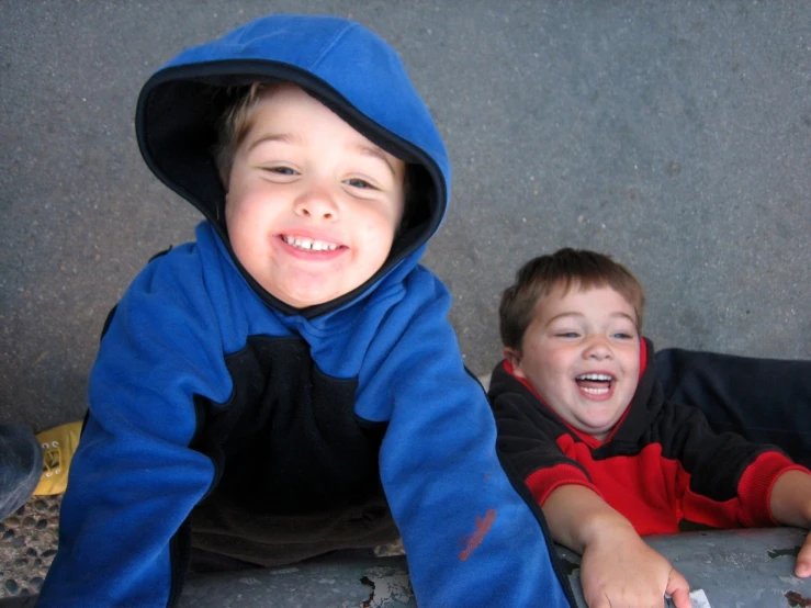 two small children are sitting down on the floor