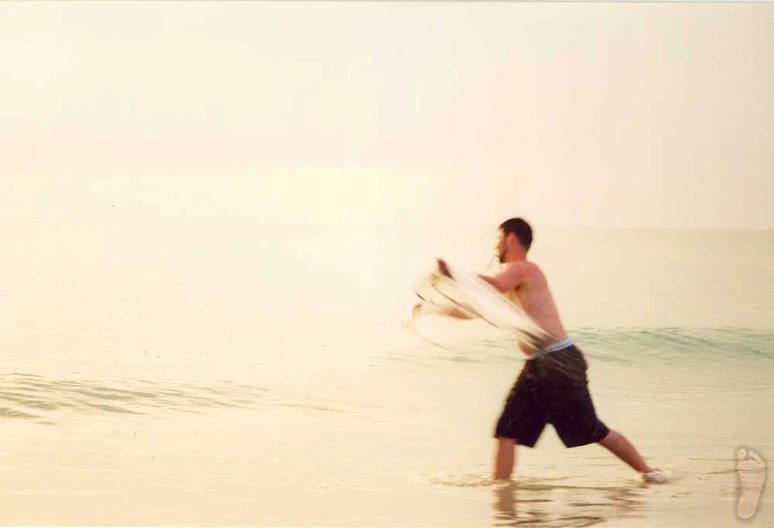 a man walking in the water with a surf board