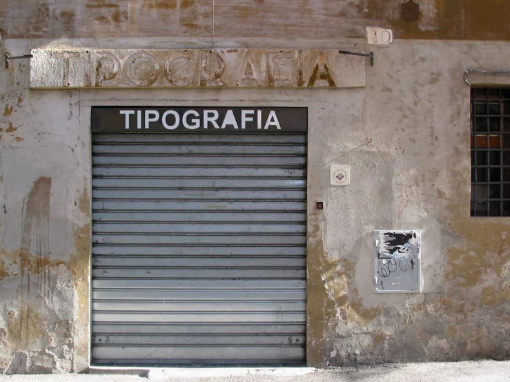 an industrial building has a closed garage door and foreign letters